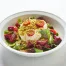 A white bowl filled with Burrata cheese with mixed greens, beets, tomatoes, and crushed pistachios, dressed in extra-virgin olive oil, vinegar and truffle sea salt.